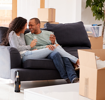 Man and woman on couch, surrounded by boxes