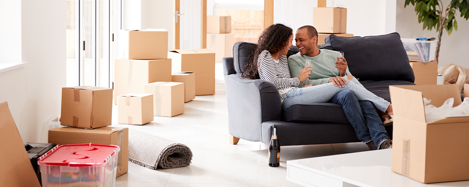 Man and woman on couch, surrounded by boxes